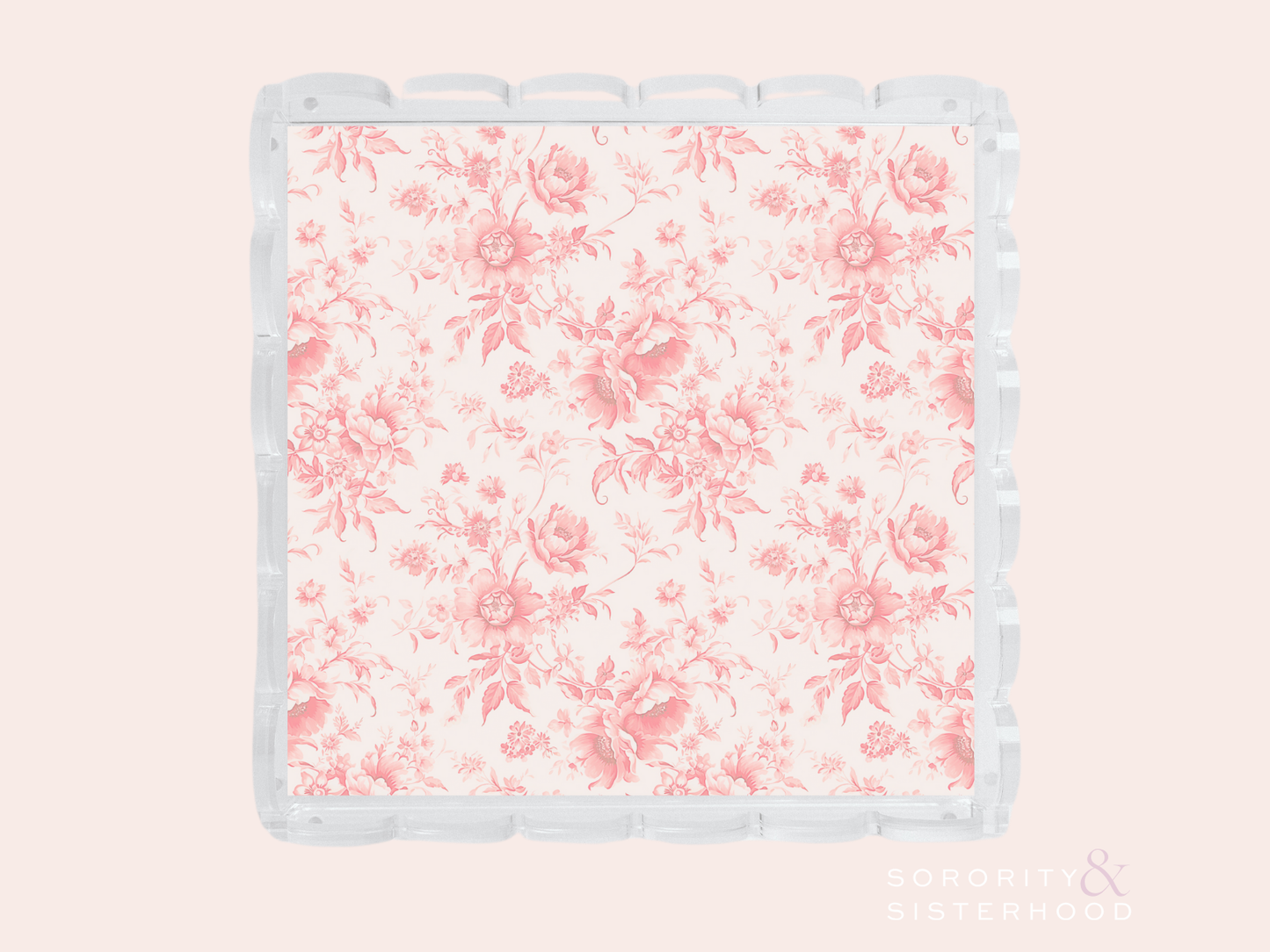Clear acrylic tray with scalloped edges and pink floral pattern on base.