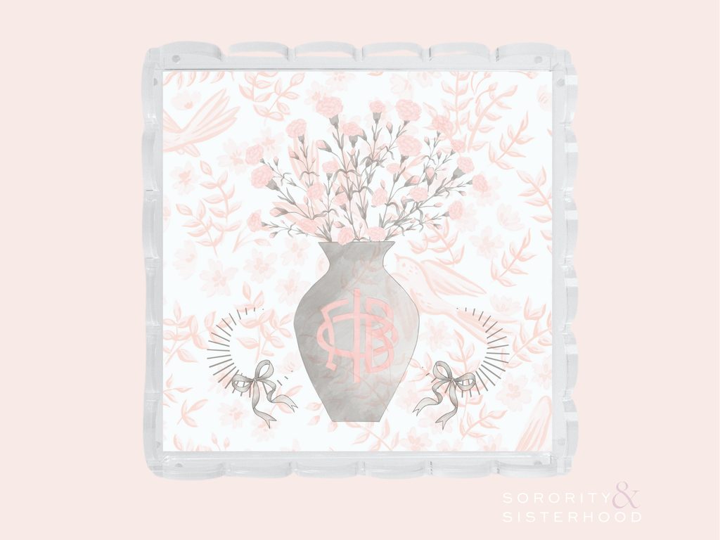 White scalloped tray with gray vase holding pink flowers and Gamma Phi Beta letters, surrounded by pink floral patterns.