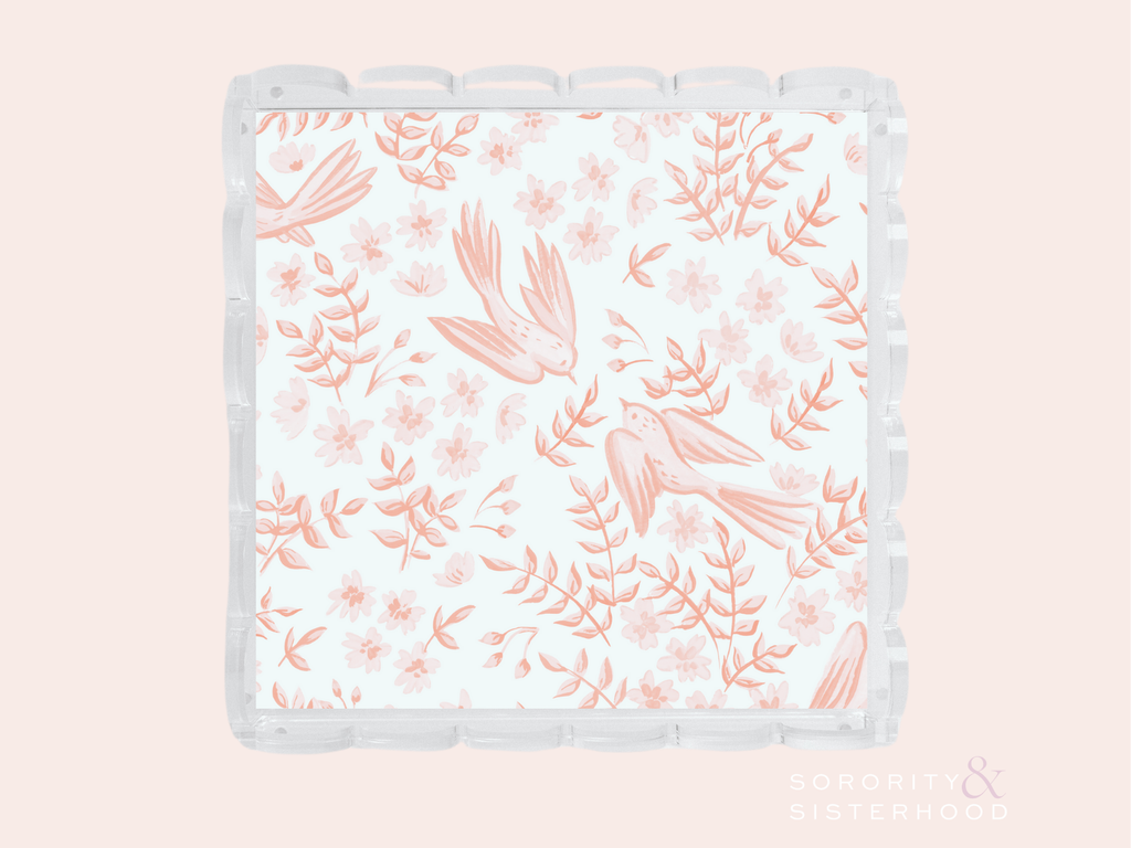 Clear scalloped tray with coral pink floral and bird pattern on white background.