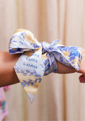 Silky scarflette in cream and blue with floral design and Kappa Kappa Gamma script tied around wrist.