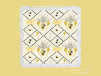 Square ceramic tray with scalloped edges, cream background, gold hearts, bows, and black diamond pattern.