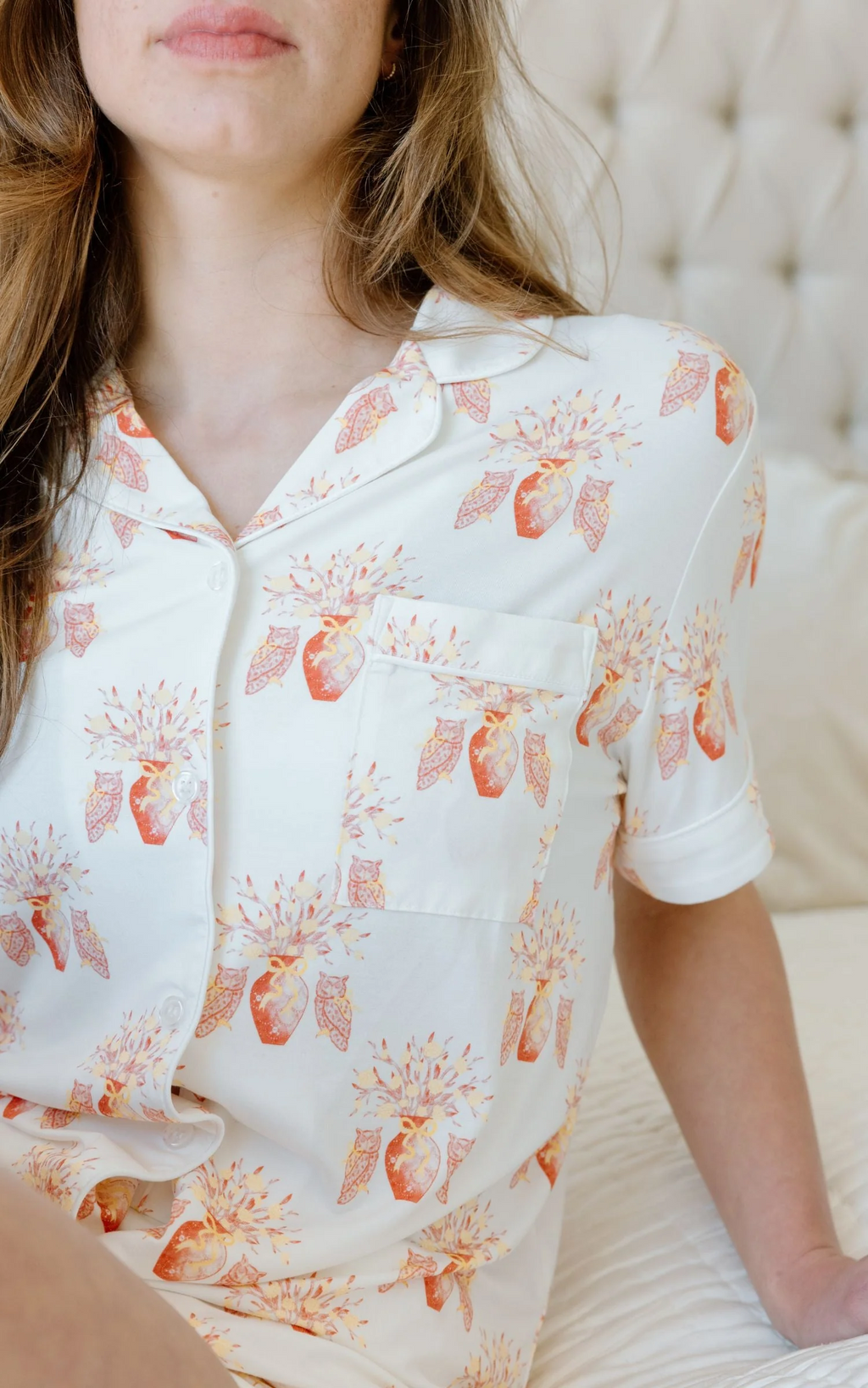 White button-up pajama top with orange floral and leaf print, short sleeves, and chest pocket.