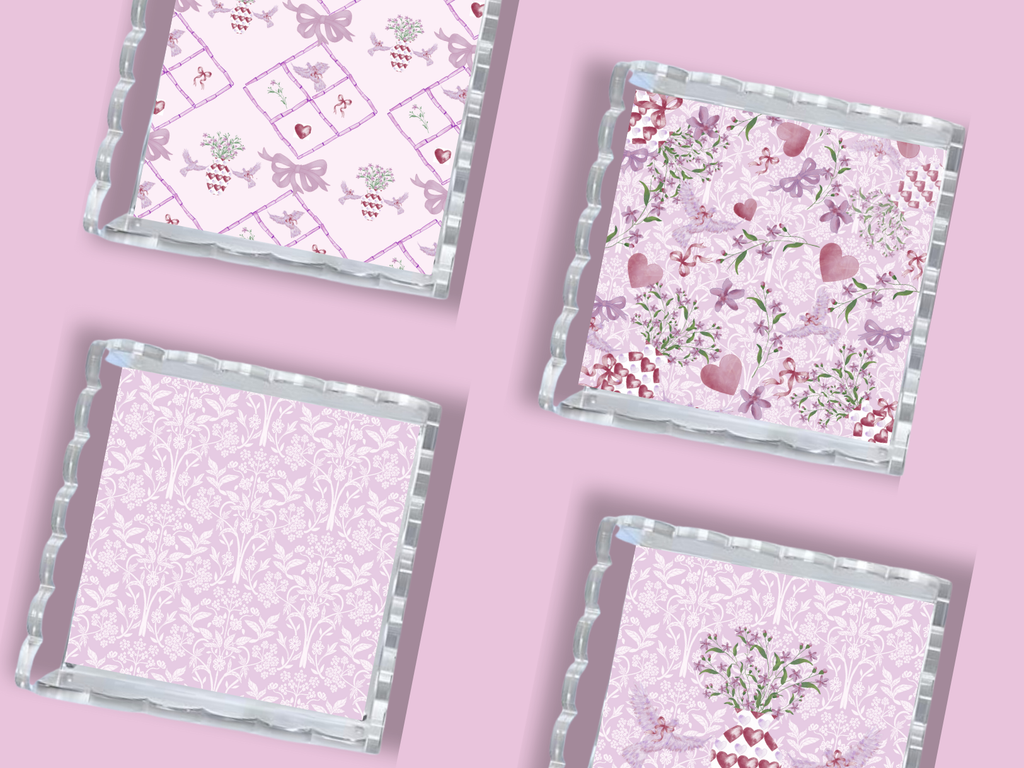Set of four square trays with scalloped silver edges and pink floral patterns on a lavender background.
