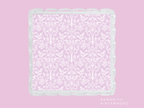 Lavender scalloped tray with white damask pattern and glossy scalloped edges.