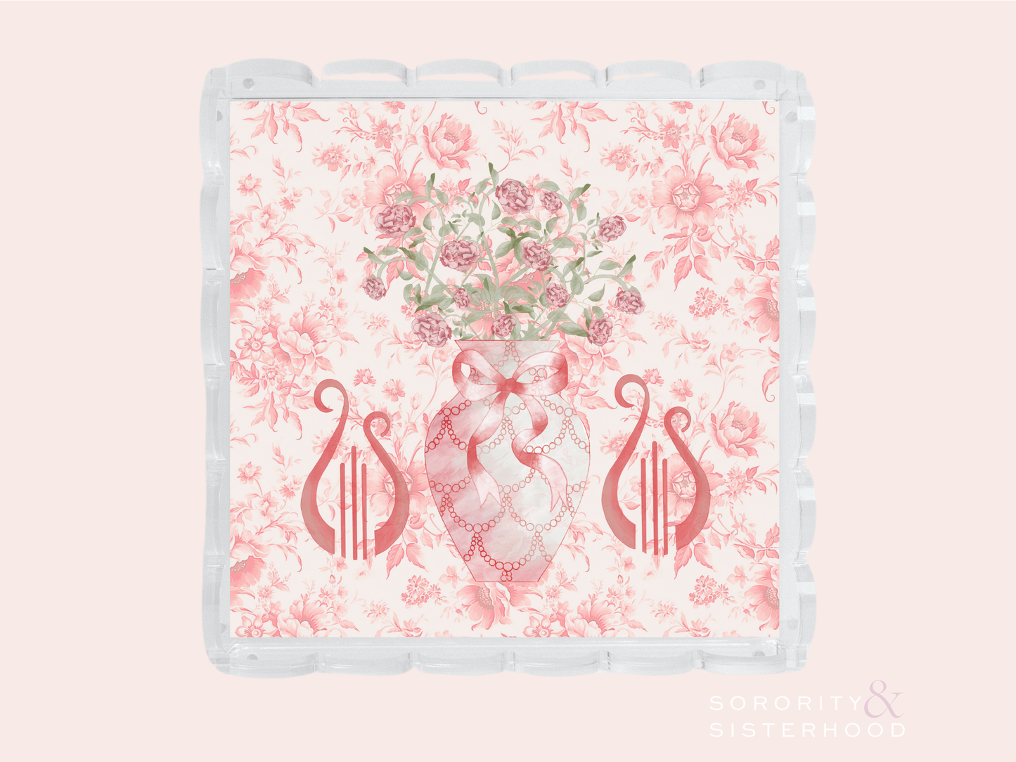 Clear acrylic tray with scalloped edges, pink floral background, lyre symbols, and floral pineapple design in center.