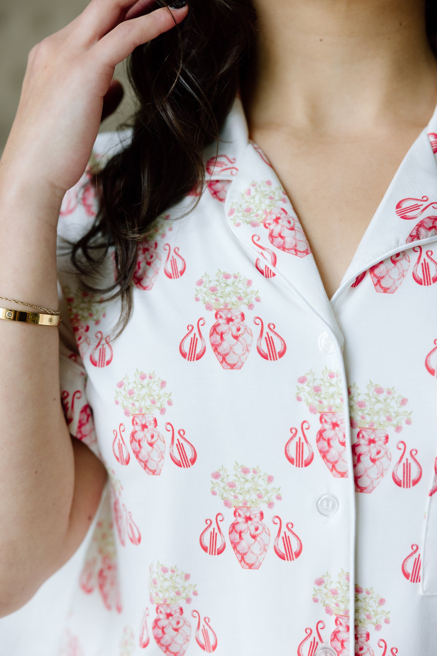 White pajama top with pink strawberry and floral print, button-down front, and notched collar.