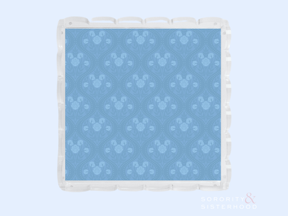 Blue acrylic tray with scalloped edges and subtle floral pattern embossed on surface.