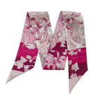 Pink and white scarflette with floral and ribbon patterns and Alpha Phi lettering.
