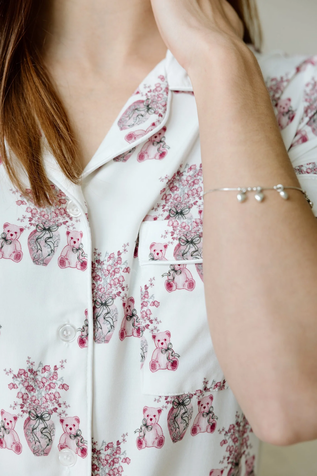 White pajama top with pink floral and elephant print, featuring a notched collar and button front.
