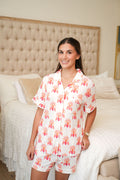 White short-sleeve pajama set with red elephant print, button-up top and matching shorts.