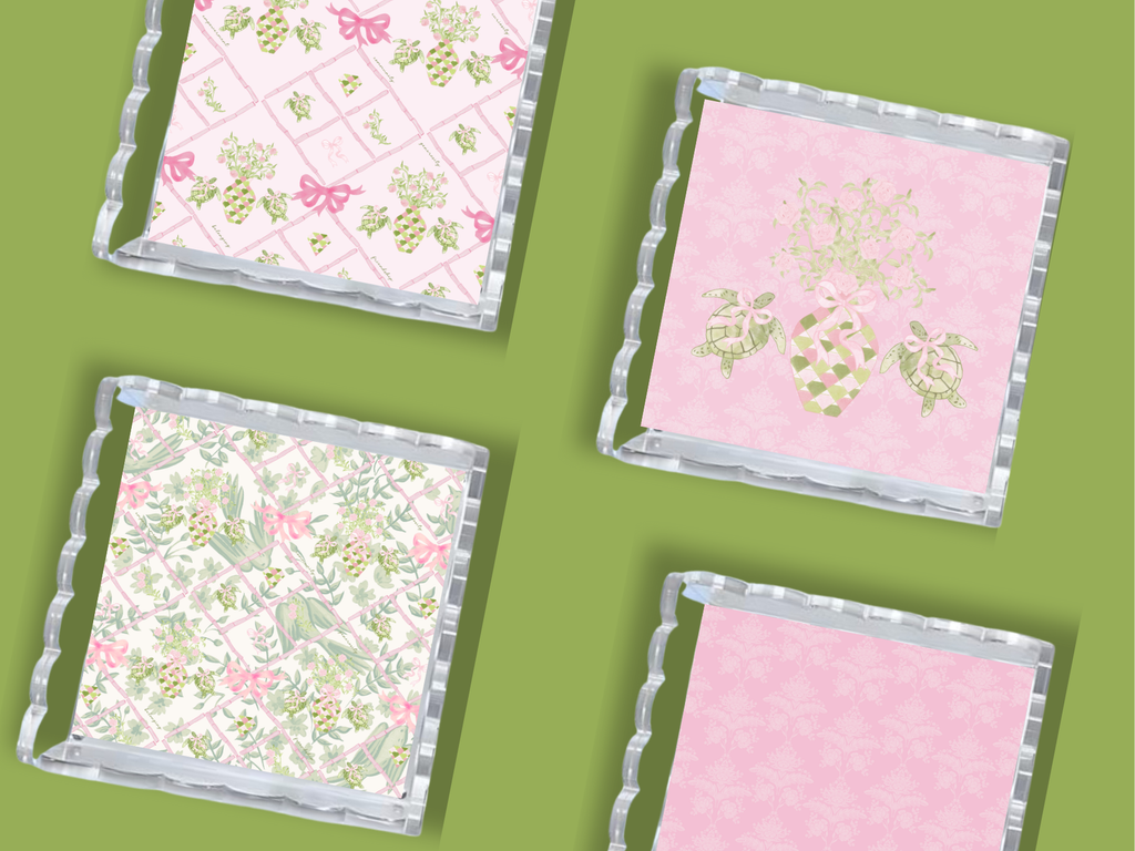 Set of four acrylic trays with scalloped edges featuring Delta Zeta sorority symbols and floral patterns in pink, white, and .