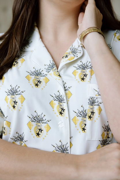 White short-sleeve pajama shirt with button collar and gold kite-and-floral print