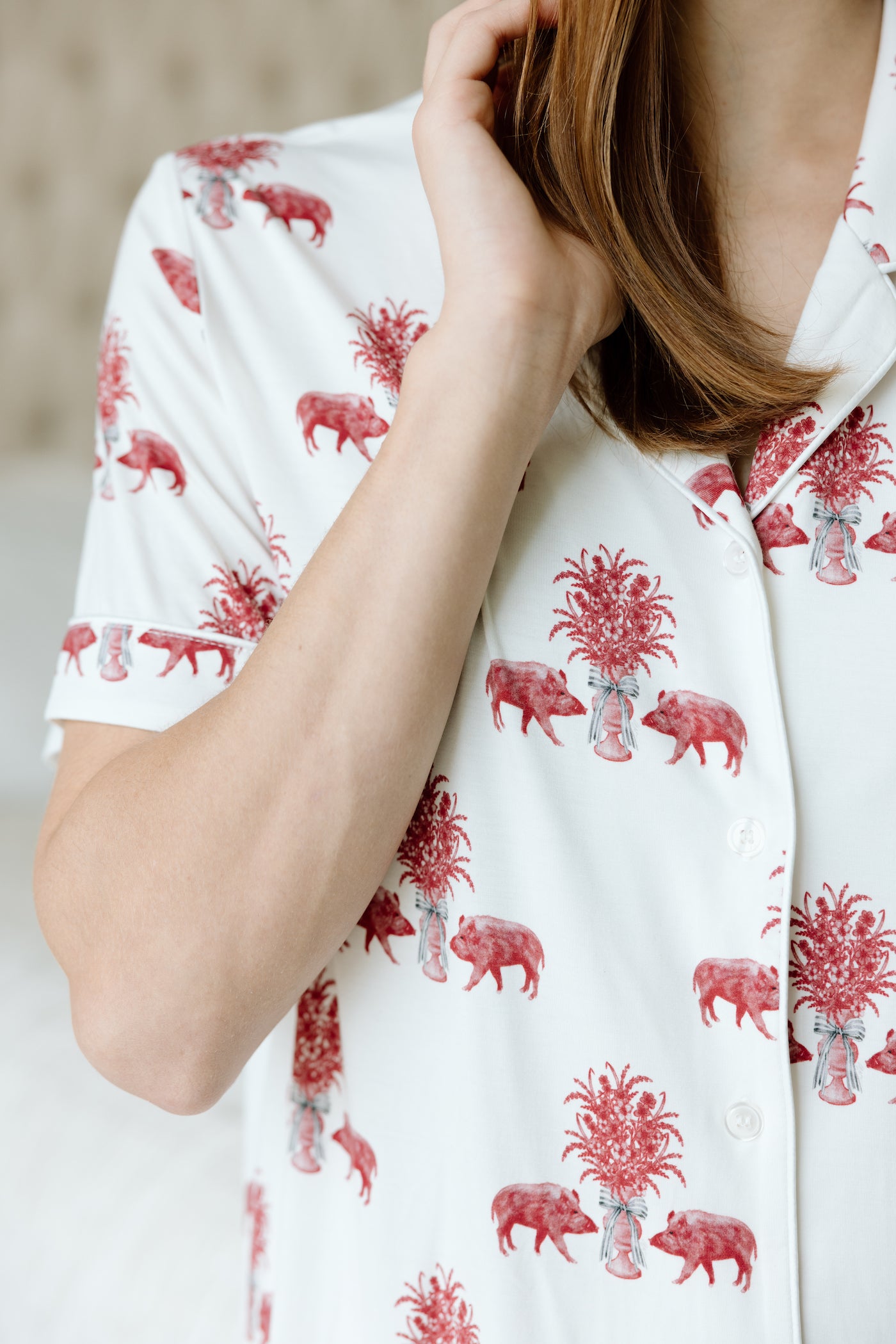 White pajama top with cardinal red heirloom animal and plant print, short sleeves, and button closure.