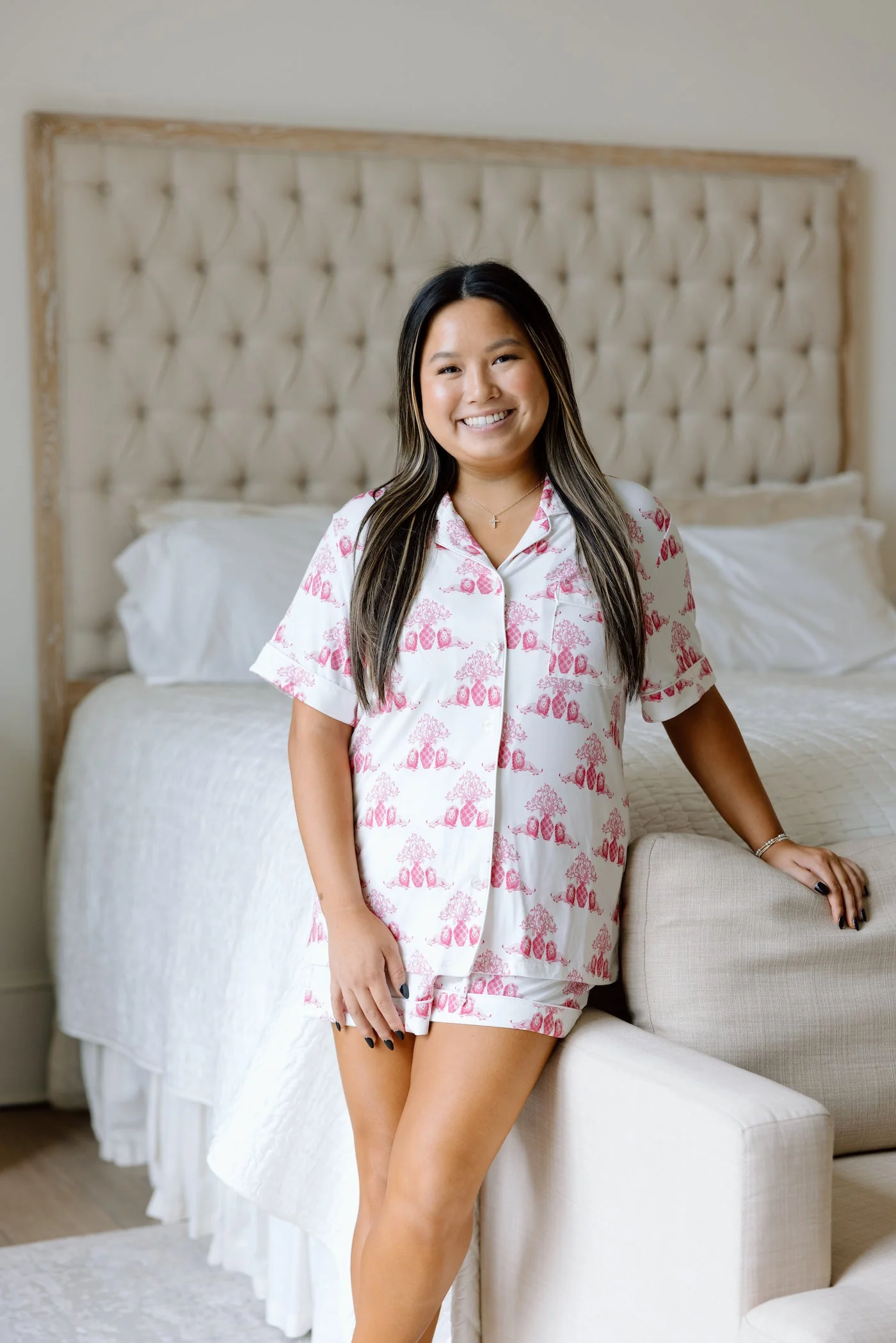 White pajama shorts set with pink elephant print, short sleeves, and button-up front worn by model.